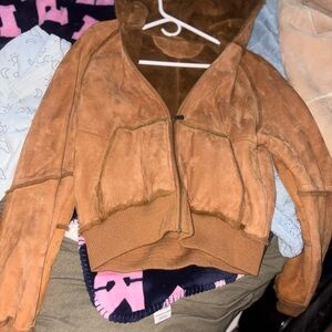 Luxurious woman tan shearling coat by UGG. Perfect for warmth and style.